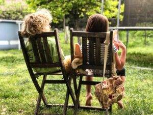 2 child sitting in a rocking chair